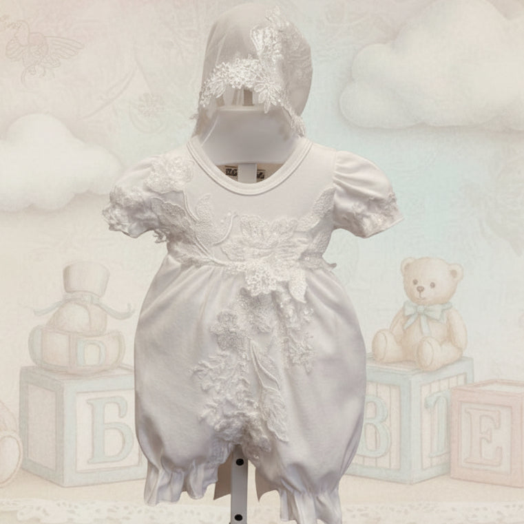 White baby romper with lace details on a mannequin against a pink background